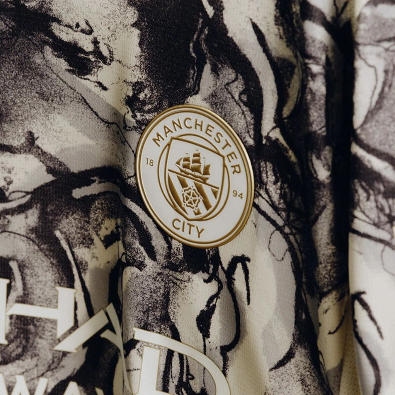 Close-up of the Manchester City club crest on the Year of the Horse 2026 pre-match jersey.